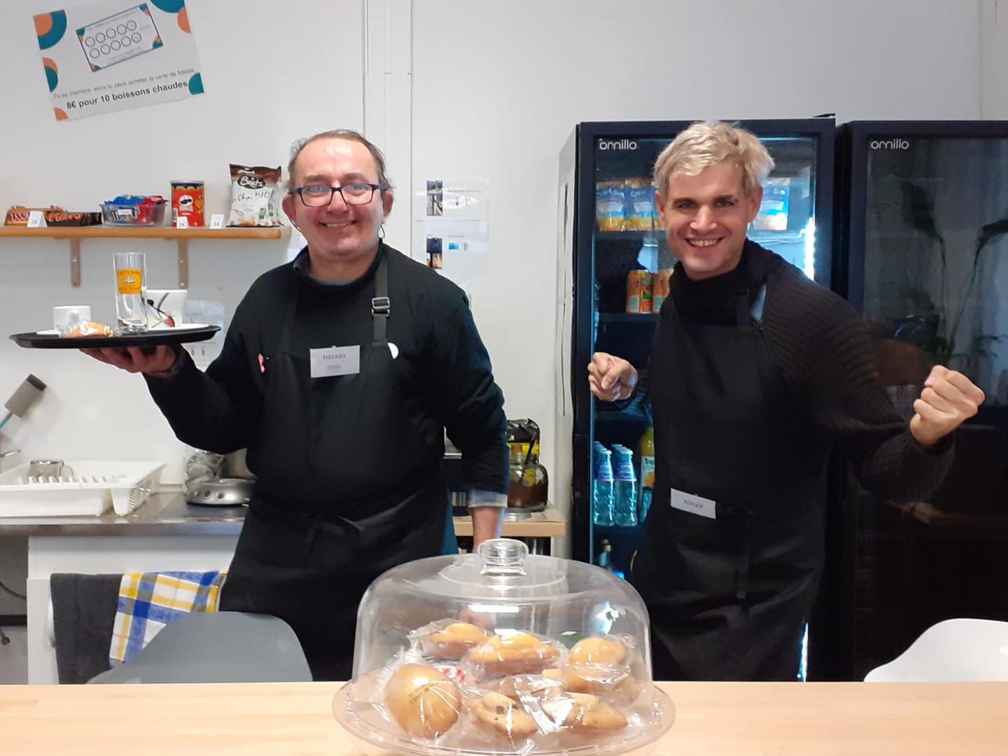 membres du café qui posent et sourient un plateau à la main